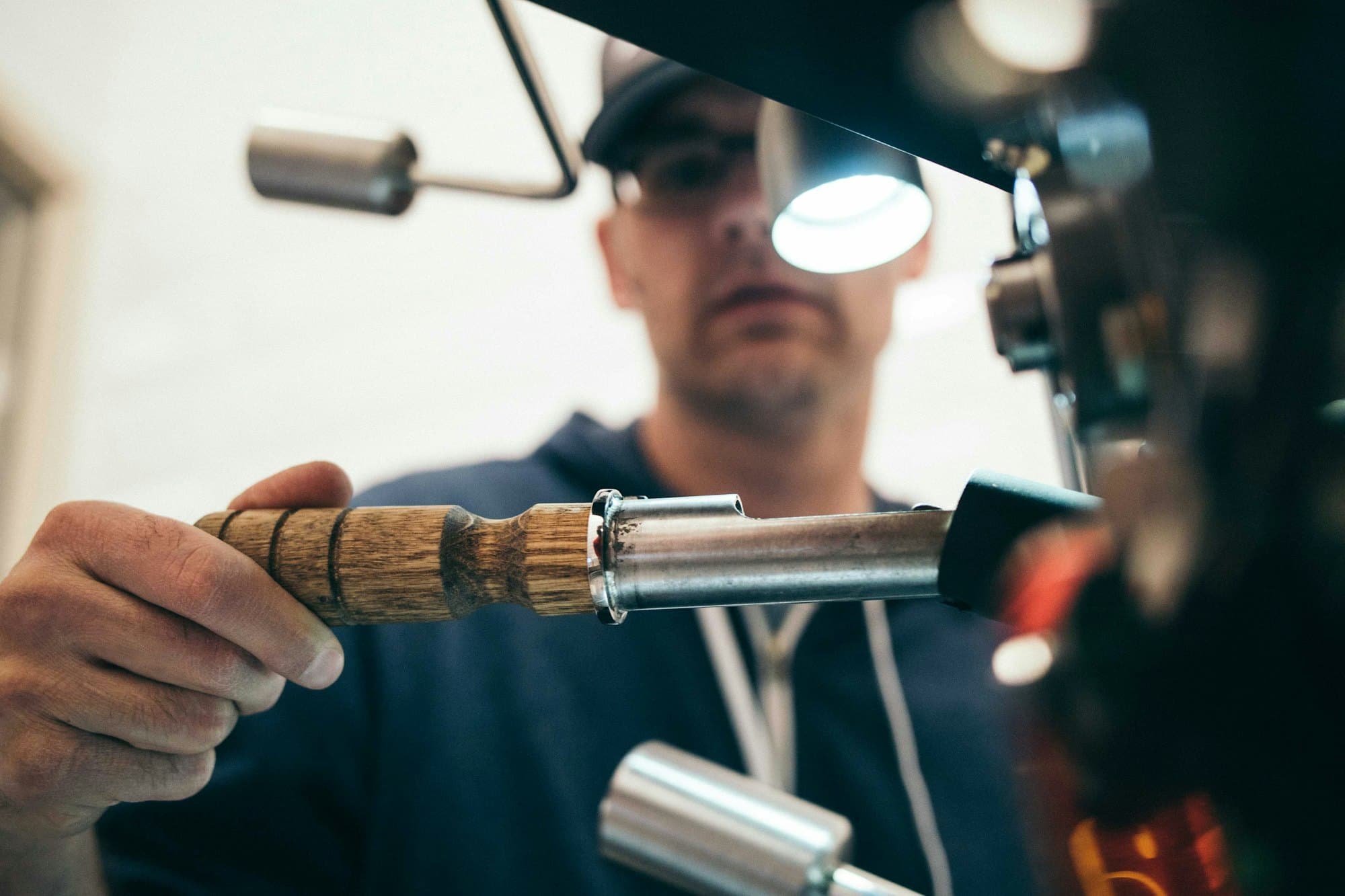 Slotenmaker-vakman aan het werk: hand met precisie-instrument, hoofdlamp, werkbank.
