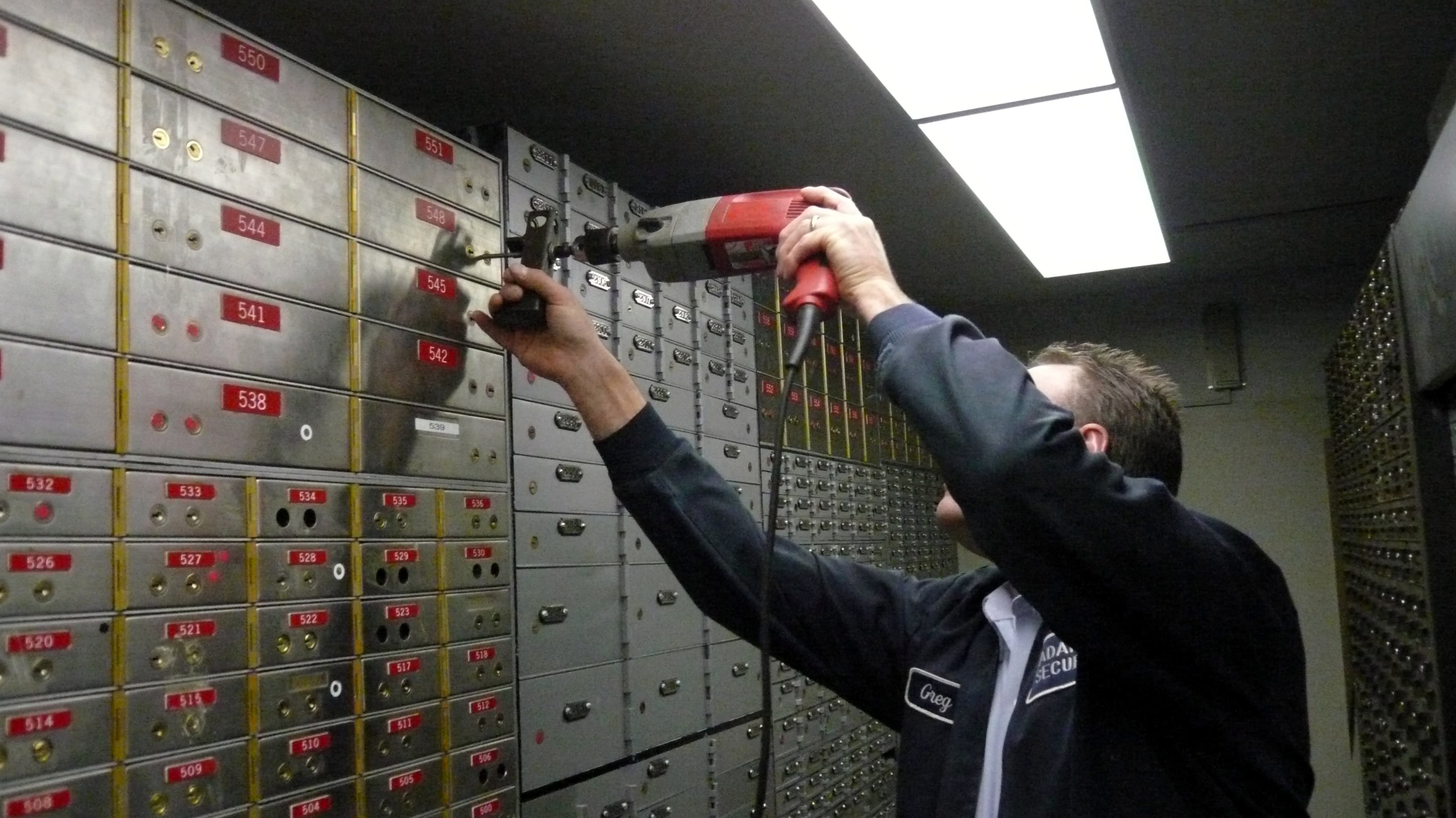 Kluisopening: vakman aan het werk, handen op het mechanisme en gereedschap uitgestald.